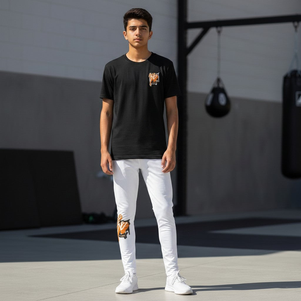 Roll Gear Tap Hype Youth BJJ Spats – Orange & White, teen boy standing outdoors, front view.