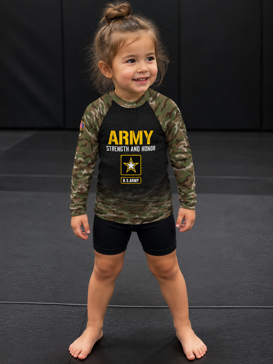 Roll Gear Kids Army Classic Long Sleeve Rash Guard, worn by a smiling young girl on the mat.
