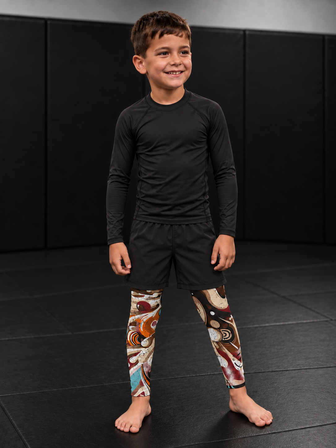Roll Gear Never Accept Training Spats – Black/Multicolor – Kids, worn under shorts by a young athlete.