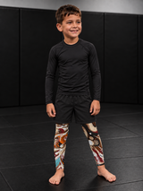 Roll Gear Never Accept Training Spats – Black/Multicolor – Kids, worn under shorts by a young athlete.
