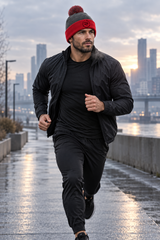 Roll Gear Beanie, dark heather grey and red pom-pom beanie on a man jogging in the city.