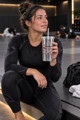 Roll Gear Always Blooming Clear Double-Wall Tumbler, woman in training gear drinking from it in the gym.