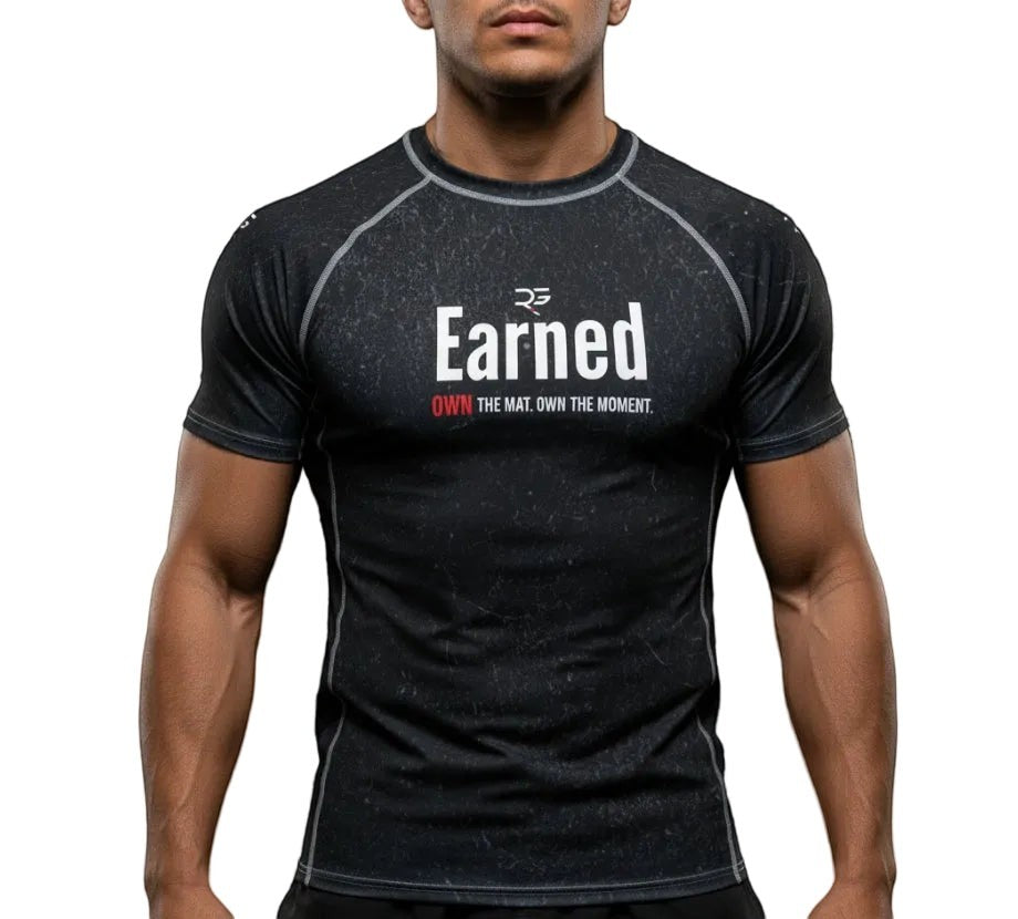 Roll Gear Earned Not Given Short Sleeve Rash Guard – Black, front view on a male model.