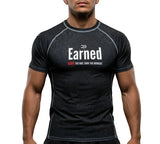 Roll Gear Earned Not Given Short Sleeve Rash Guard – Black, front view on a male model.