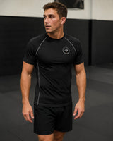Roll Gear black short-sleeve performance rash guard with grey contrast stitching and logo on chest. Unisex adult fit.