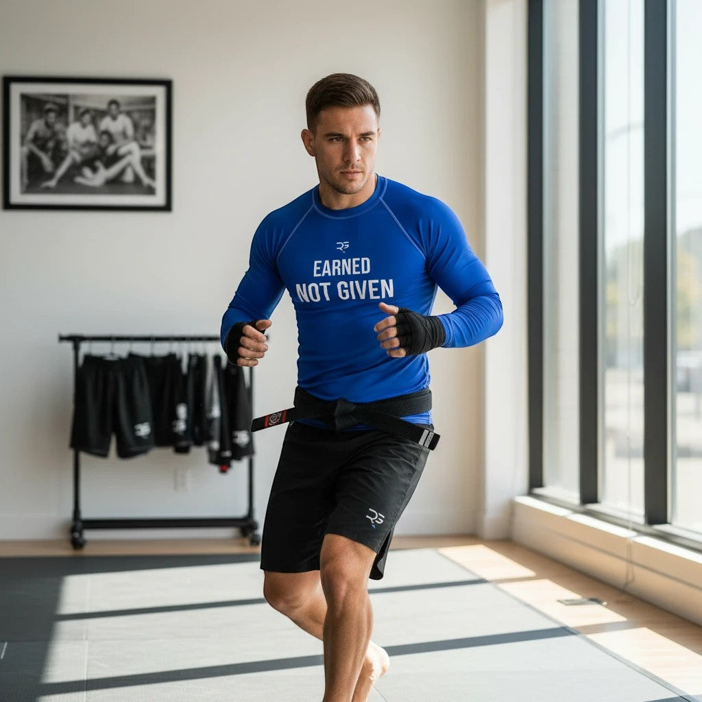 Roll Gear Excuses Don’t Burn Calories Men’s Long Sleeve Rash Guard – Blue, man training in a home gym, front view.