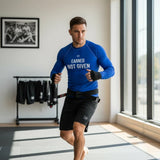 Roll Gear Excuses Don’t Burn Calories Men’s Long Sleeve Rash Guard – Blue, man training in a home gym, front view.