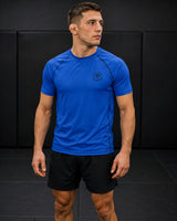 Roll Gear blue short-sleeve performance rash guard with black seams and logo, worn by a male athlete.