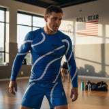 Roll Gear men's blue long sleeve rash guard with white swirl accents and "Earned Not Given" graphic. Performance fabric.