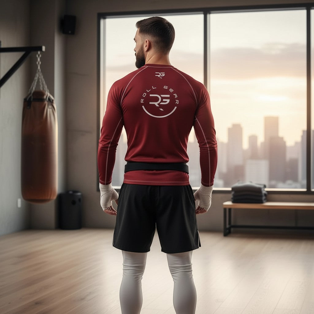 Roll Gear Earned Not Given Long Sleeve Rash Guard – Deep Red – Men’s, back view on a man by a window.