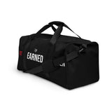 Black polyester training duffel bag by Roll Gear with "Earned Not Given" graphic and adjustable shoulder strap.
