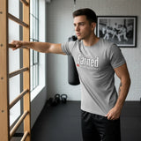 Roll Gear grey cotton t-shirt with "Earned Not Given" graphic print, short sleeves, crew neck, worn by a man in a gym.