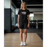 Roll Gear black cotton t-shirt with white and red "EARNED NOT GIVEN" graphic print on front. Model in gym.