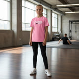 Roll Gear pink cotton youth t-shirt with "EARNED NOT GIVEN" graphic, unisex fit, in a gym setting.