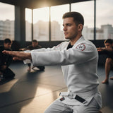 Roll Gear circular embroidered patch with RG logo in white, red, and black on a man's grey BJJ rashguard.