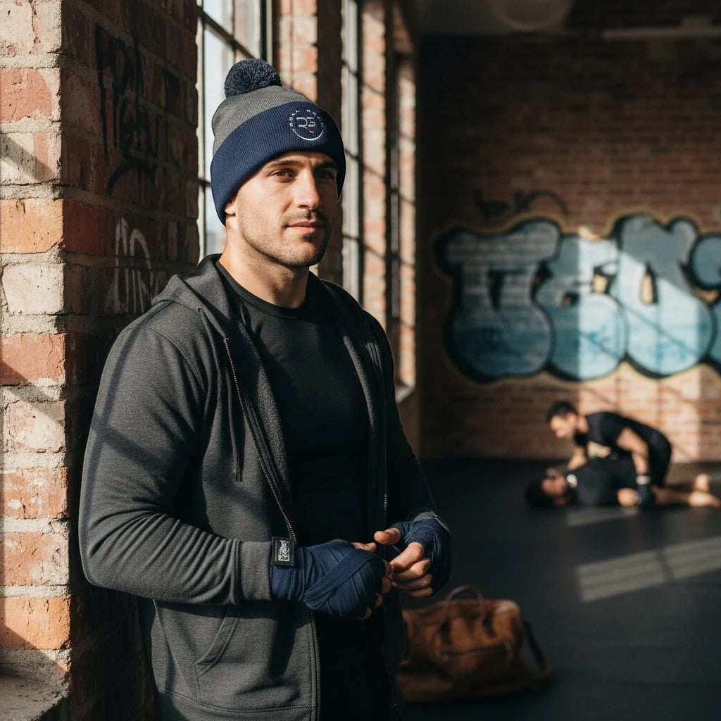 Roll Gear blue and grey knit pom pom beanie hat with embroidered logo on cuff.