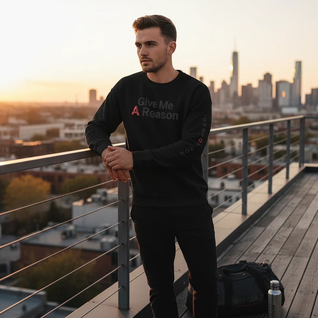 Roll Gear black crewneck sweatshirt with "Give Me A Reason" graphic on front and sleeve text. Model leans on railing.