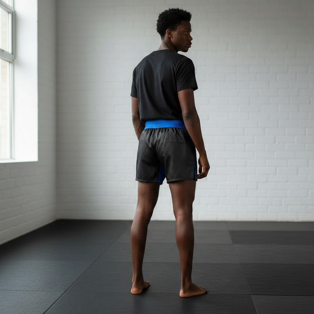 Roll Gear Police Tribute Edition black grappling shorts with blue trim and waistband, featuring a split-leg design for mobility.