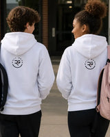 Two people wearing matching light grey Roll Gear hoodies, seen from behind, walking outside a building entrance