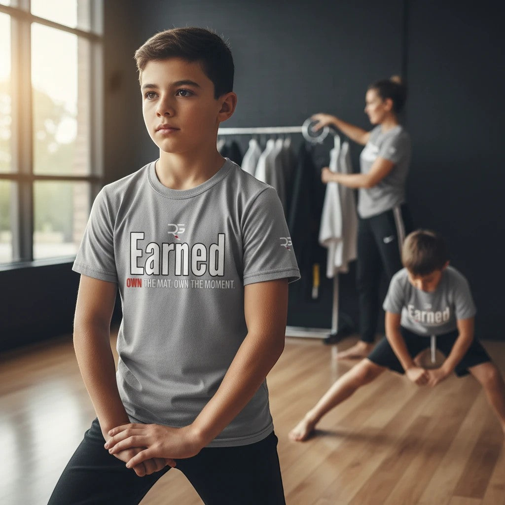 Roll Gear grey short-sleeve t-shirt with "Earned" graphic and motivational text for kids. Lightweight, breathable fabric.