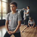 Roll Gear grey short-sleeve t-shirt with "Earned" graphic and motivational text for kids. Lightweight, breathable fabric.