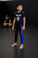 Roll Gear black compression spats for kids with blue thin line panels, ideal for BJJ and active play.