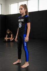 Roll Gear black polyester-spandex compression spats for kids with blue side panels and "POLICE" graphic.