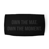 Roll Gear LLC black polyester duffel bag with "OWN THE MAT. OWN THE MOMENT." text.