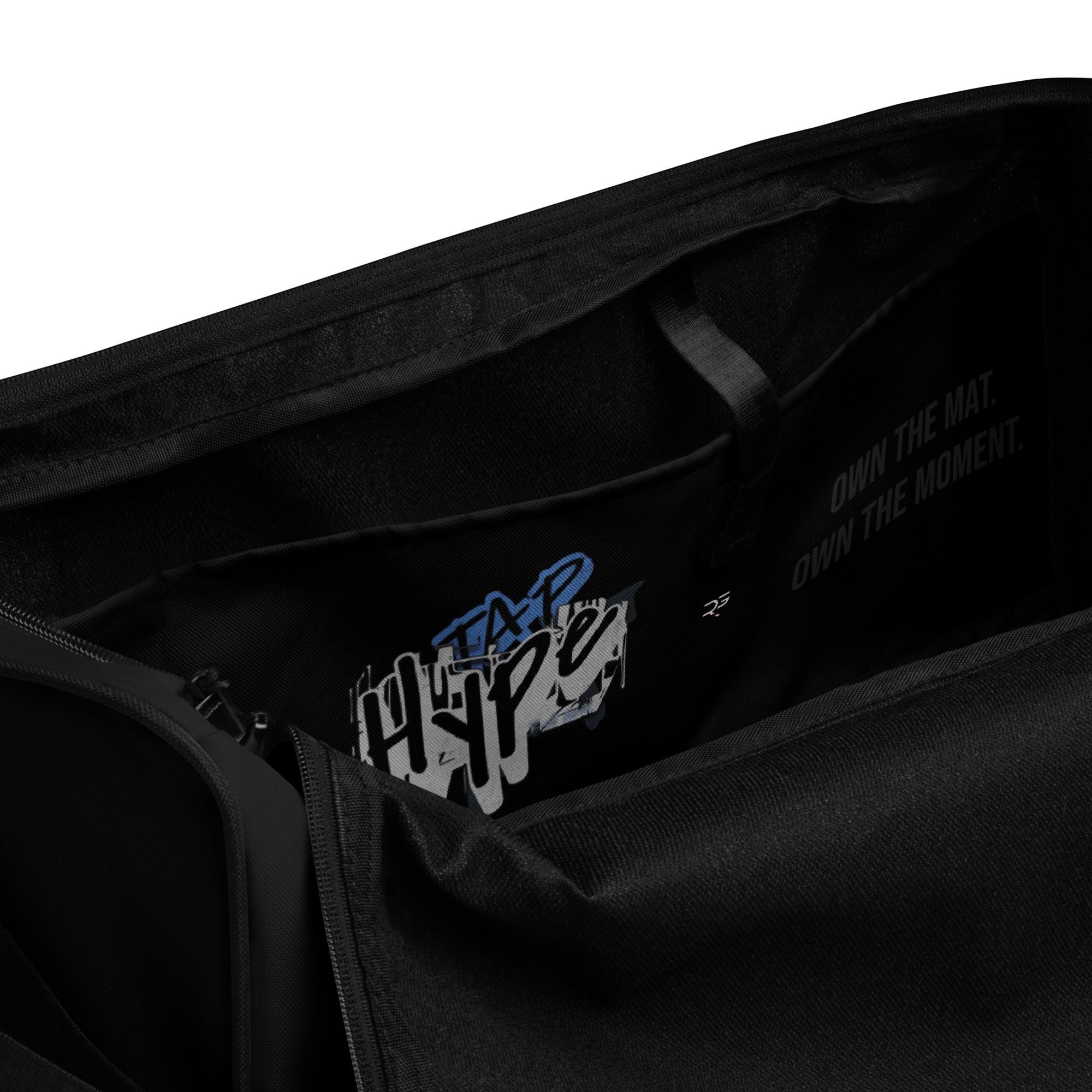 Black polyester Roll Gear LLC training duffel bag with "Earned Not Given" graphic and motivational text.