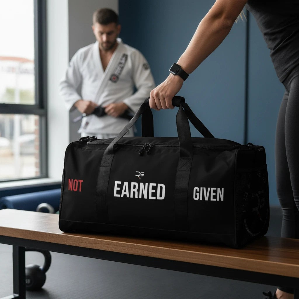 Roll Gear LLC black polyester duffel bag with "Earned Not Given" text, mesh side pocket, and dual handles.