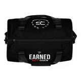 Roll Gear LLC black polyester cylinder duffel bag with "Earned Not Given" graphic and side artwork. Features padded handles and a detachable strap.