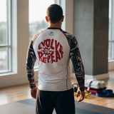 Roll Gear Evolve or Repeat Men’s Long Sleeve Rash Guard, back view on a man showing the Evolve or Repeat graphic.