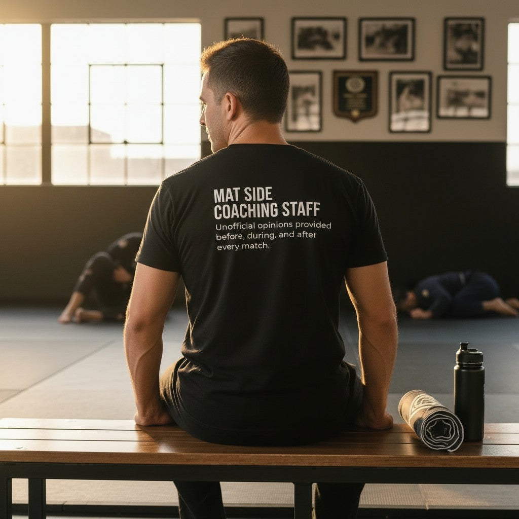Black heavyweight tee shown with both prints, Full-Time Mat Analyst front and Mat Side Coaching Staff back.
