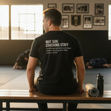 Black heavyweight tee shown with both prints, Full-Time Mat Analyst front and Mat Side Coaching Staff back.