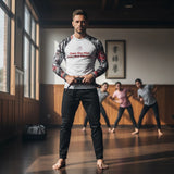 Roll Gear Evolve or Repeat Men’s Long Sleeve Rash Guard – White & Red, front view, worn while tying a belt in the dojo.