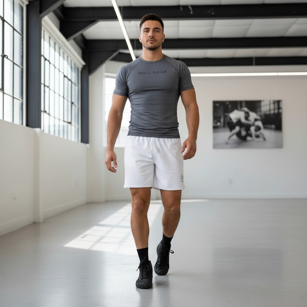 Roll Gear Mesh Shorts – All White – Unisex, worn by a man walking in a gym.