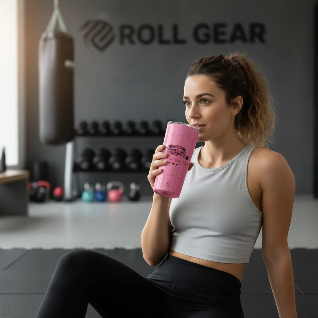Roll Gear pink 20oz stainless steel tumbler with 'Girls on the Mat' logo, held by a woman in a gym.