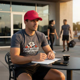 Roll Gear red trucker hat with embroidered logo, mesh back for ventilation, and curved bill. Worn by a man sitting at a table.