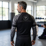Roll Gear Men's SWAT Edition long sleeve rash guard in black with urban camo sleeves and tactical graphics.