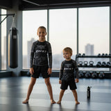 Roll Gear Kids SWAT Edition Long Sleeve Rash Guard, worn by two young athletes standing in the gym.