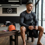 Roll Gear orange trucker cap with mesh back and embroidered logo, sitting on a wooden bench next to a water bottle.