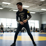 Roll Gear Youth Marines "Gold" long sleeve rash guard in black with faded gold sleeves and USMC emblem. Compression fit for athletic training.