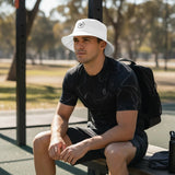 Roll Gear white 100% cotton twill bucket hat with embroidered logo, worn by a man outdoors.