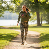 Roll Gear Women’s Crop Hoodie – Pink Edition, woman walking on a park trail.