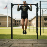 Roll Gear Women’s Marines Gold military rash guard, black with faded gold sleeves and USMC emblem, performing pull-ups.