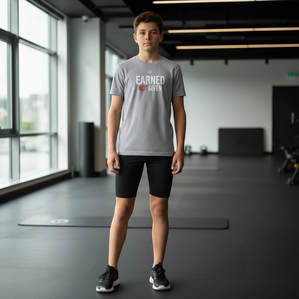Roll Gear Youth Earned Not Given T-Shirt, teen boy standing in a gym.