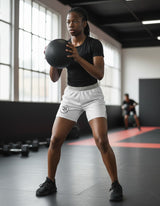 Roll Gear youth white grappling shorts with grey waistband and side panels, featuring the Roll Gear logo.