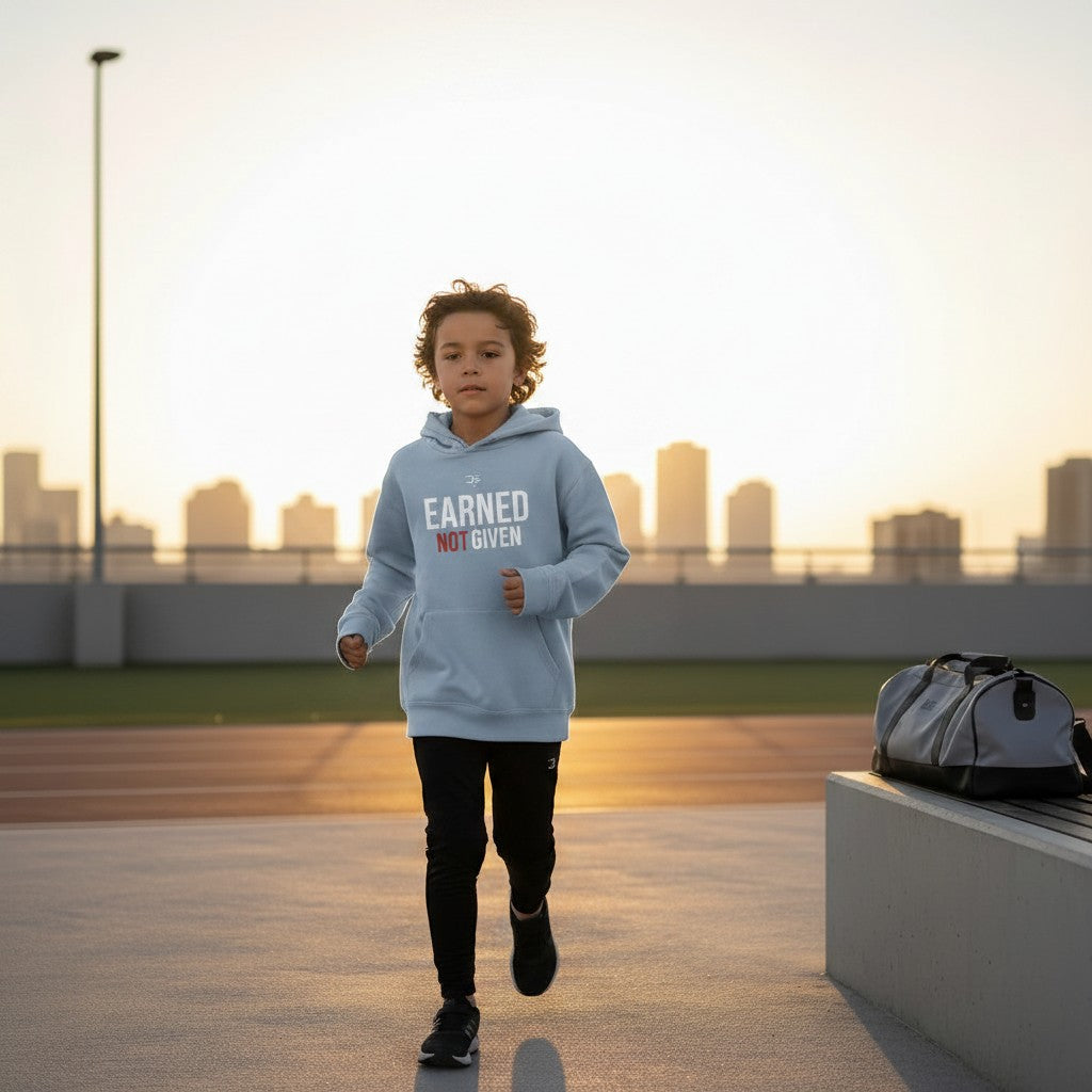 Roll Gear light blue garment-dyed cotton youth hoodie with "Earned Not Given" graphic on back and logo on front.