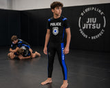 Roll Gear youth black compression spats with blue thin line panels and police graphics, made of polyester and spandex.