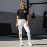 Roll Gear Tap Hype Youth BJJ Spats – Orange & White, worn by a model standing in a gym, front view.